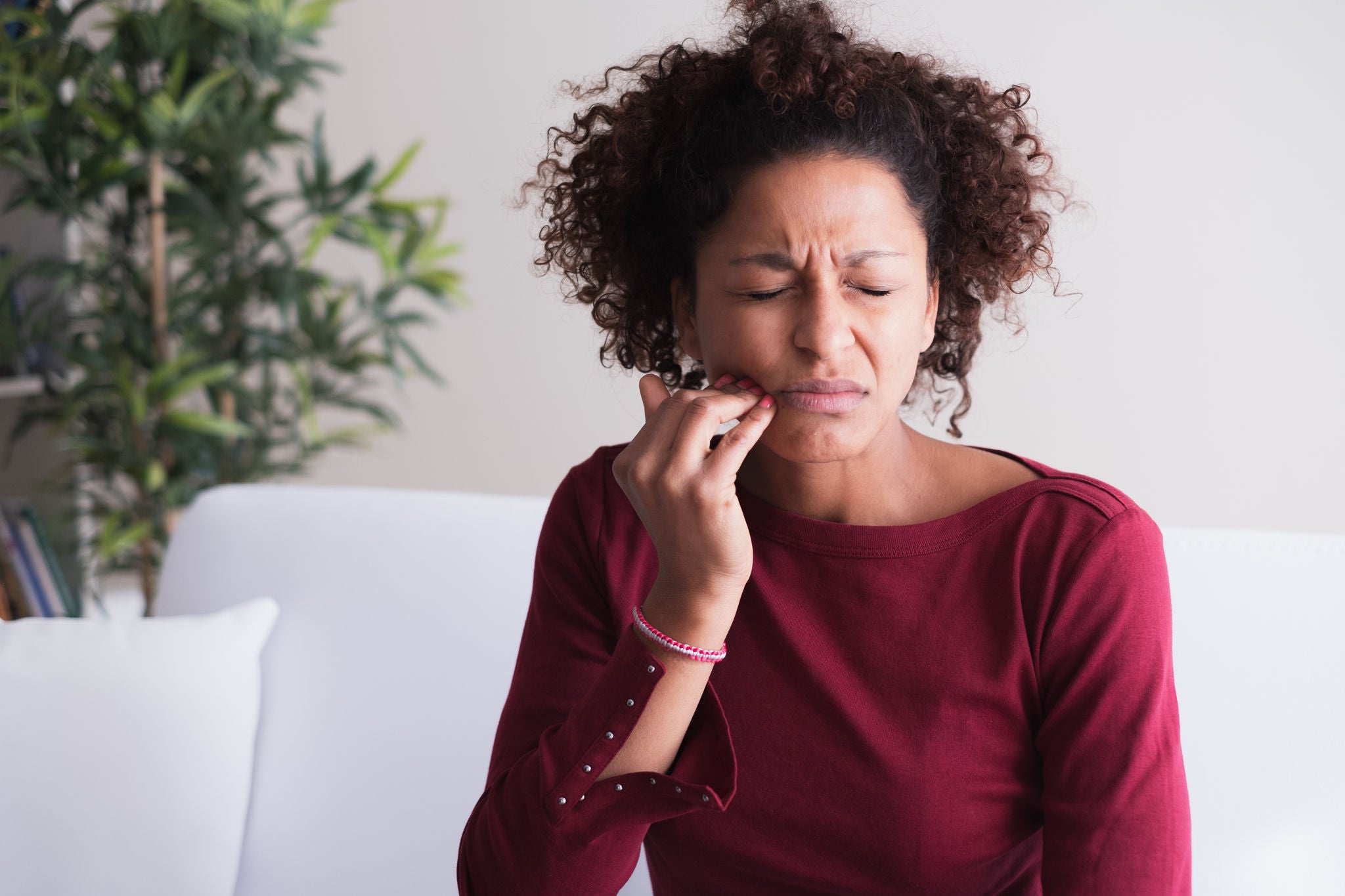 Woman feeling toothache and massaging gums