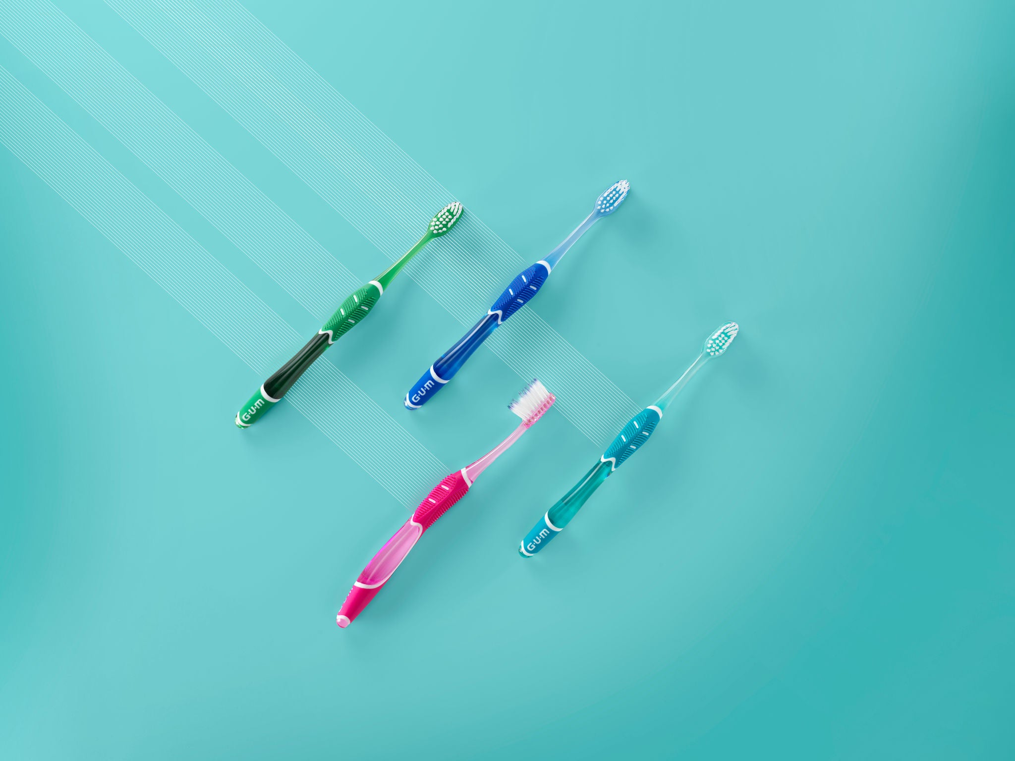 GUM PRO Toothbrush in 4 colours placed on a turquoise background