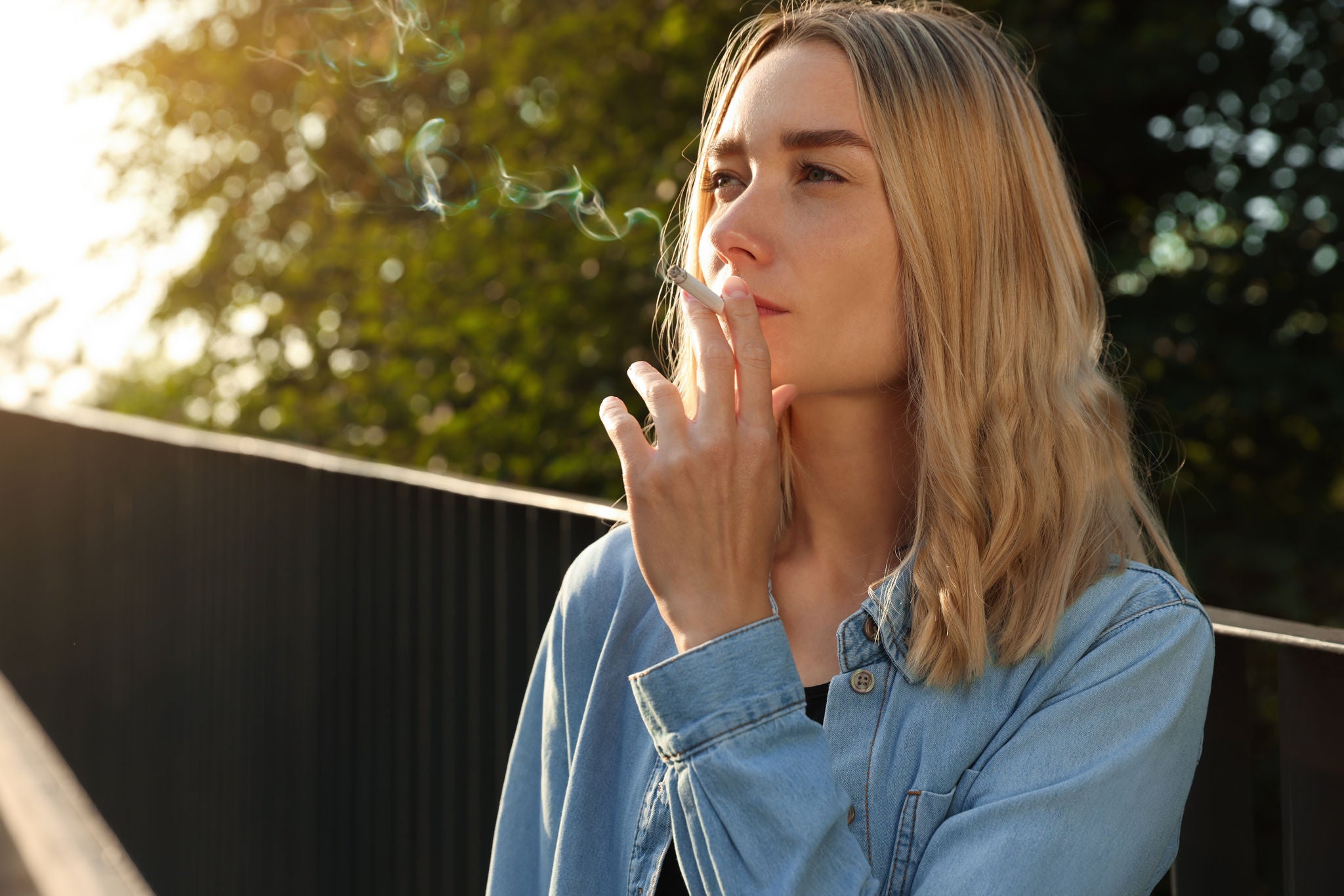 Young-woman-smoking-cigarette-outdoors