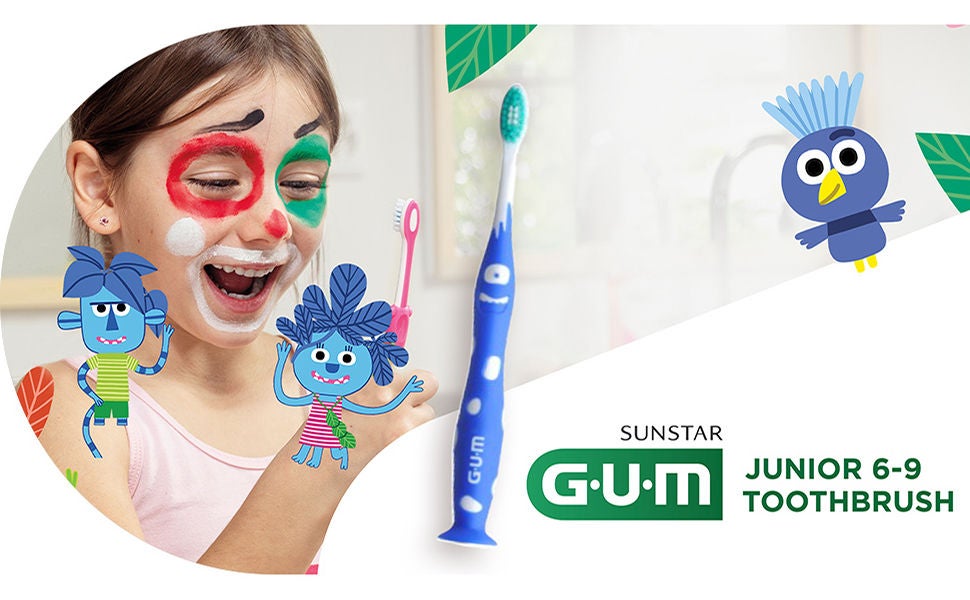 Smiling girl is holding the GUM JUNIOR toohtbrush with some jungle buddies