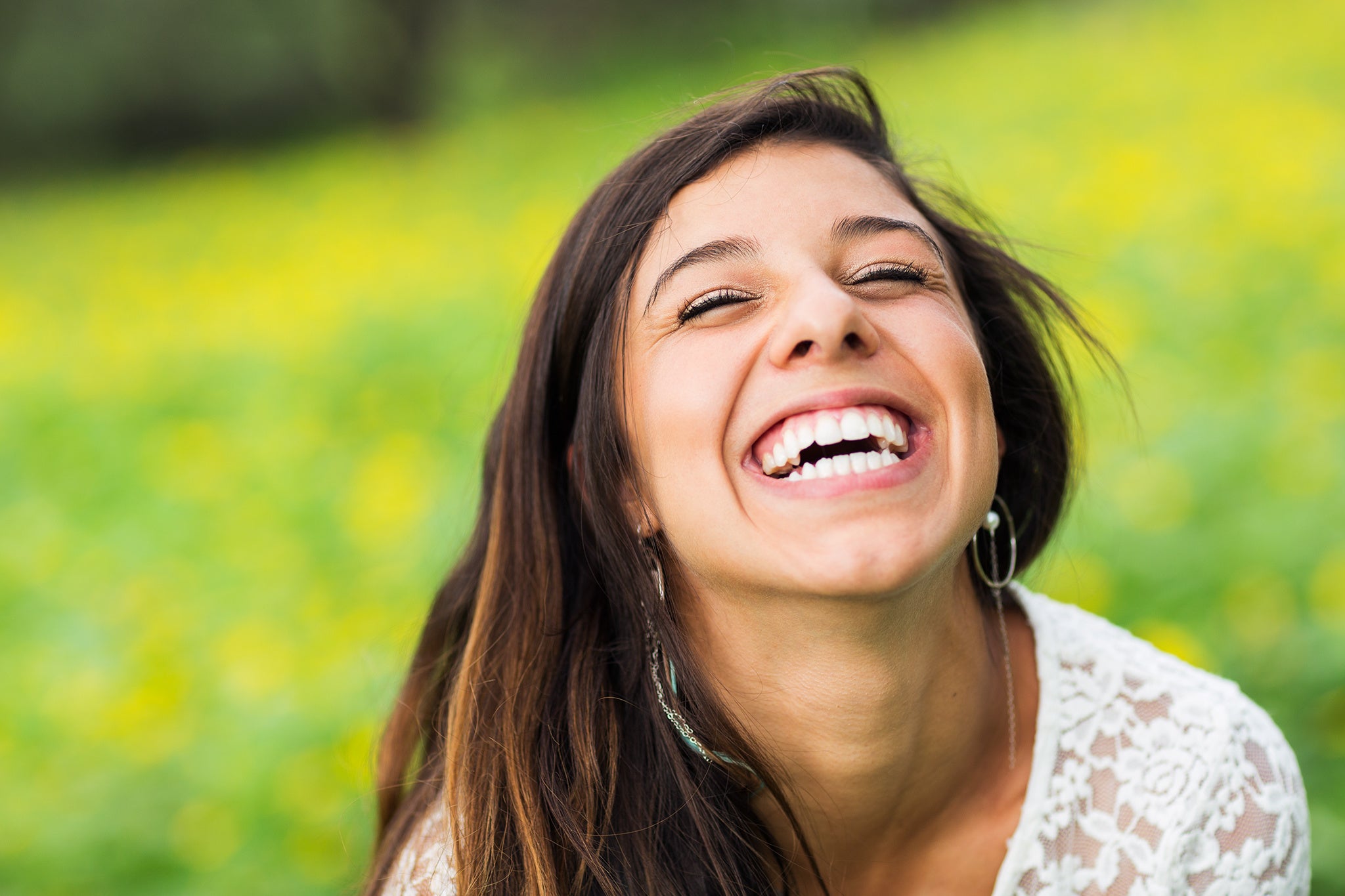 Young woman female smiling outdoor green background