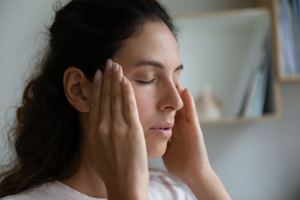 Woman-upset-tired-with-closed-eyes-touching-massaging-temple