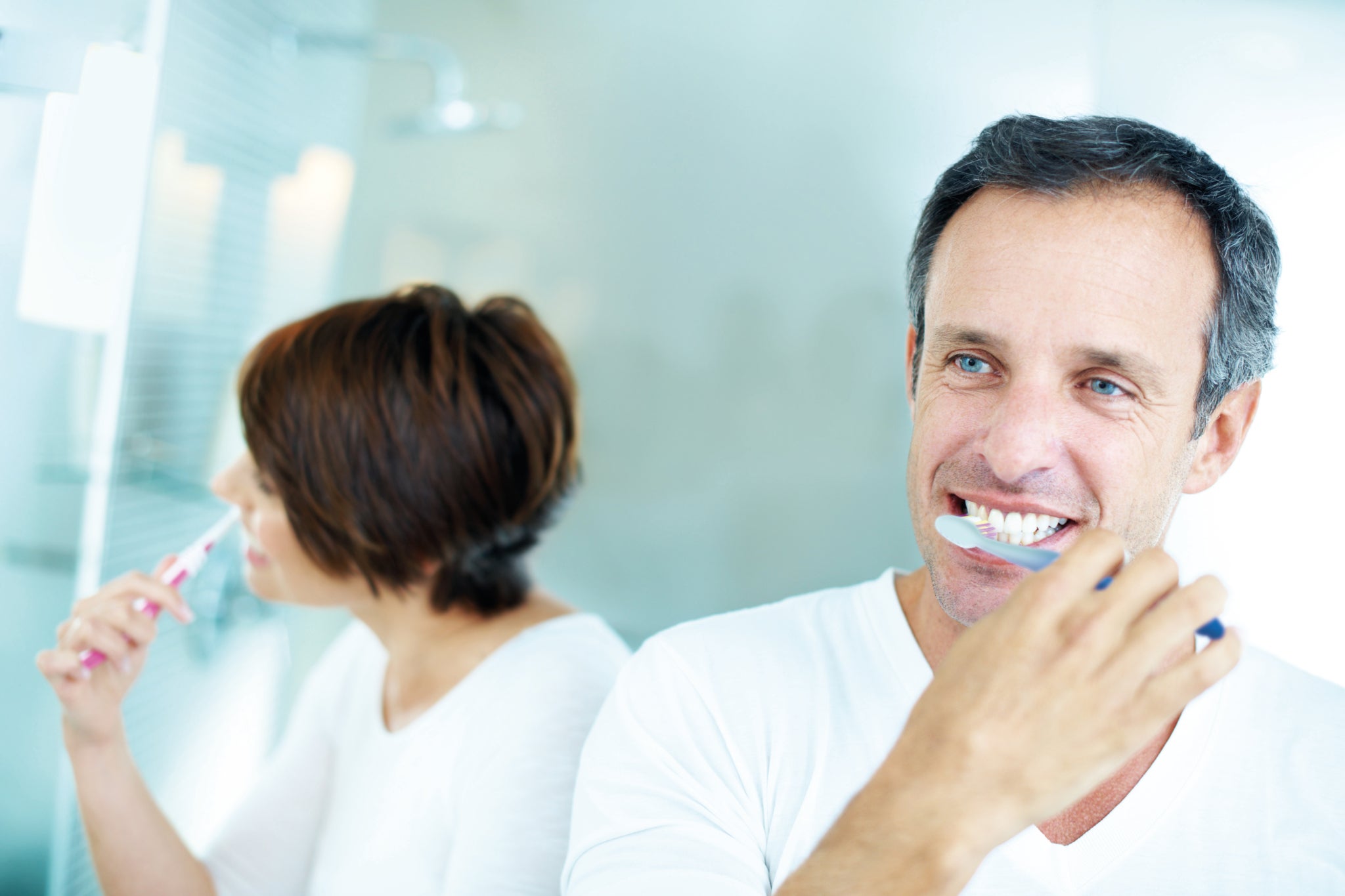 Man and woman brushing teeth