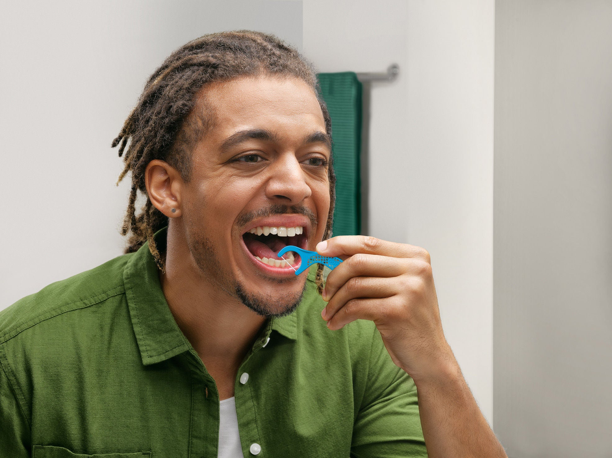 Smiling mann is cleaning between teeth with GUM EASY-FLOSSERS