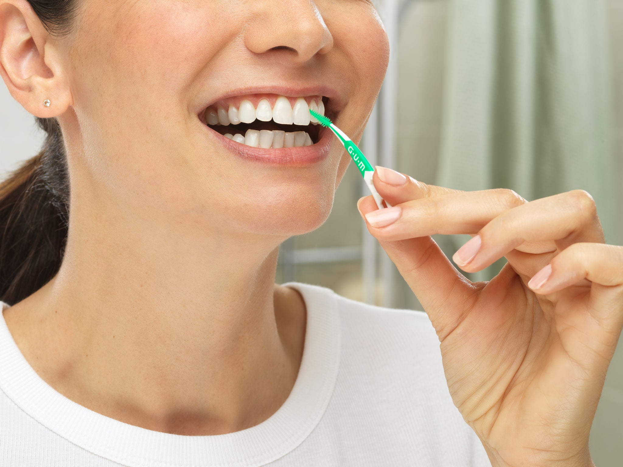 In-context-GUM-SOFT-PICKS-PRO-Close-Up-with-Smiling-Woman-Cleans-between-teeth-in-the-bathroom.jpg